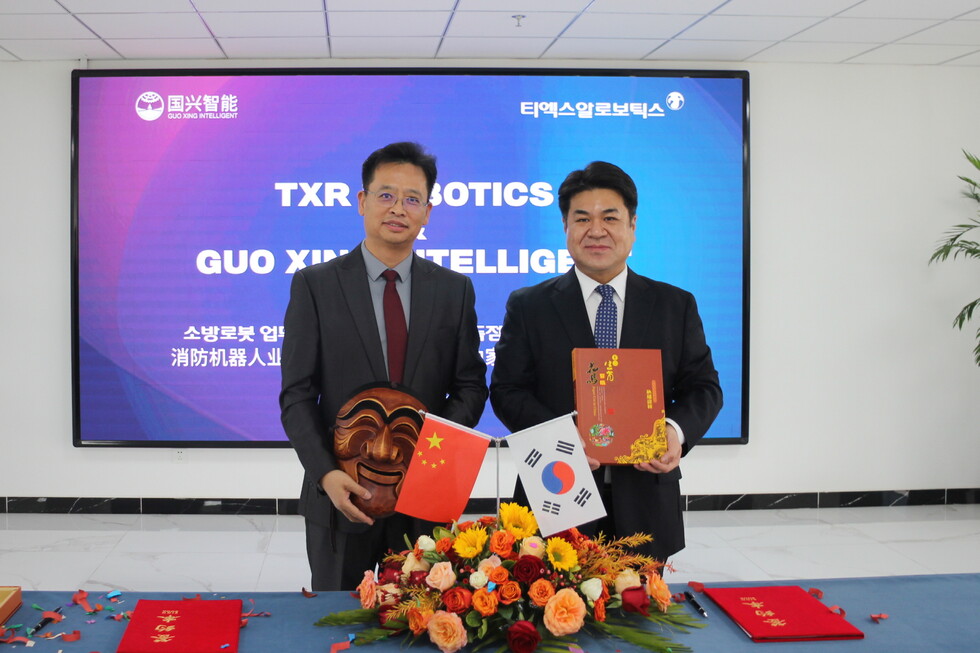 엄인섭 TXR로보틱스 대표이사(오른쪽)와 바오밍송(Bao MingSong) 궈싱즈넝(国兴智能∙GuoXing Intelligent) CEO(왼쪽)가 17일 중국 산둥성 옌타이시에서 ‘소방로봇 독점 공급 업무협약’을 체결한 뒤 기념촬영을 하고 있다.